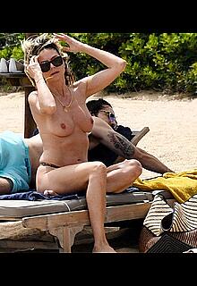 Heidi Klum in bikini and topless on a beach in Sardinia