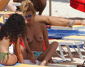 Adriana Volpe sunbathint topless on a beach