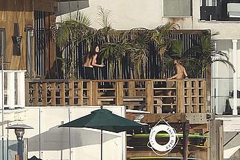 Cara Delevingne sunbathing topless on a balcony in Malibu