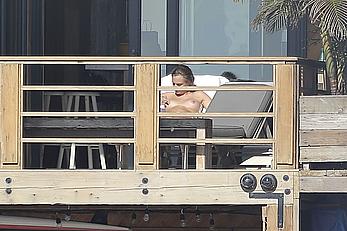 Cara Delevingne sunbathing topless on a balcony in Malibu