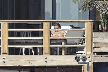 Cara Delevingne sunbathing topless on a balcony in Malibu