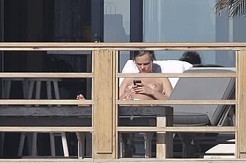 Cara Delevingne sunbathing topless on a balcony in Malibu