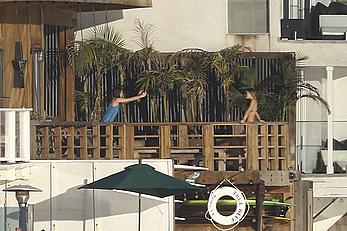 Cara Delevingne sunbathing topless on a balcony in Malibu