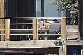 Cara Delevingne sunbathing topless on a balcony in Malibu