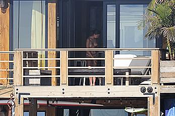 Cara Delevingne sunbathing topless on a balcony in Malibu