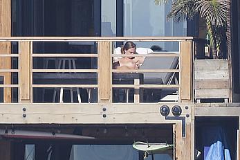 Cara Delevingne sunbathing topless on a balcony in Malibu