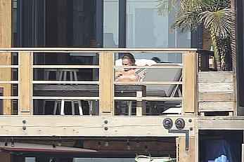 Cara Delevingne sunbathing topless on a balcony in Malibu