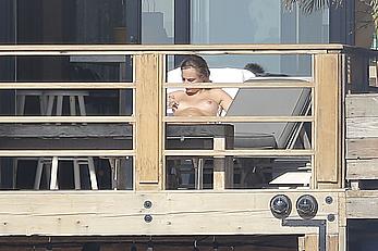 Cara Delevingne sunbathing topless on a balcony in Malibu