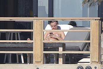 Cara Delevingne sunbathing topless on a balcony in Malibu