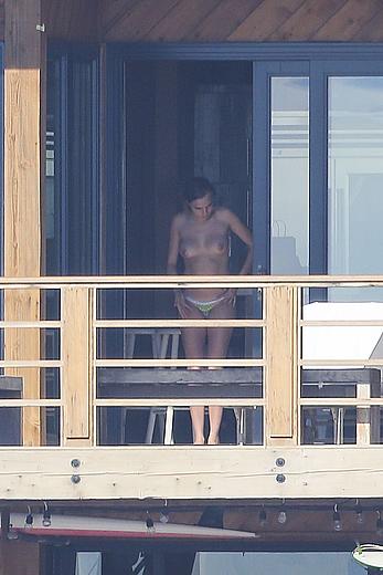 Cara Delevingne sunbathing topless on a balcony in Malibu