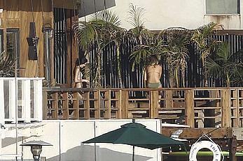 Cara Delevingne sunbathing topless on a balcony in Malibu