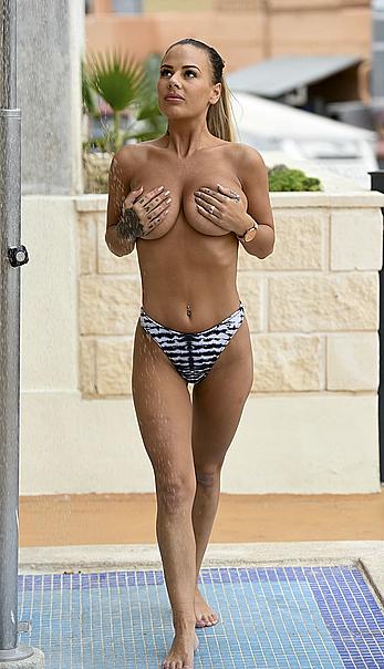 Chantelle Connelly covers her nude boobs while chilling by a pool