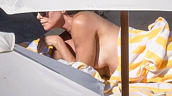 Charlize Theron sunbathing topless in Tuscany