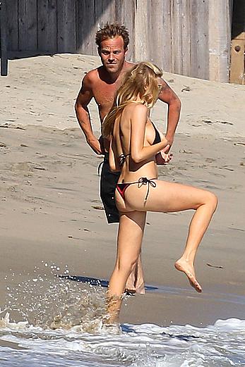 Charlotte McKinney side of boob and round ass in bikini on a beach in Malibu