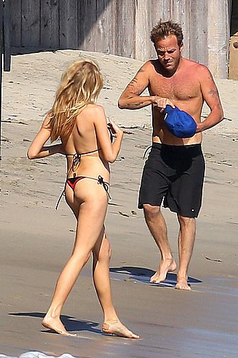 Charlotte McKinney side of boob and round ass in bikini on a beach in Malibu