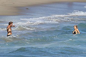 Charlotte McKinney side of boob and round ass in bikini on a beach in Malibu