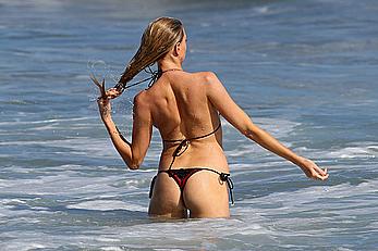 Charlotte McKinney side of boob and round ass in bikini on a beach in Malibu