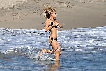 Charlotte McKinney side of boob and round ass in bikini on a beach in Malibu