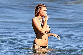 Charlotte McKinney side of boob and round ass in bikini on a beach in Malibu