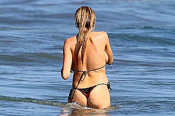 Charlotte McKinney side of boob and round ass in bikini on a beach in Malibu