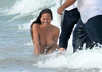 Chrissy Teigen topless during photoshoot at Miami Beach