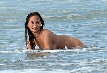 Chrissy Teigen topless during photoshoot at Miami Beach