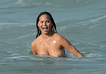 Chrissy Teigen topless during photoshoot at Miami Beach