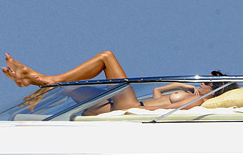 Cindy Crawford sunbathing topless on a yacht