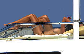 Cindy Crawford sunbathing topless on a yacht