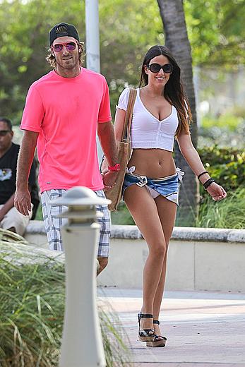 Claudia Romani on the beach in white bikini and jeans skirt