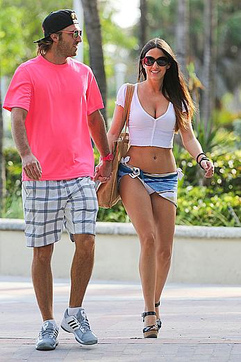 Claudia Romani on the beach in white bikini and jeans skirt