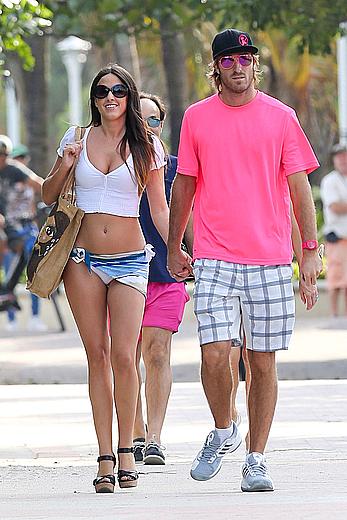 Claudia Romani on the beach in white bikini and jeans skirt