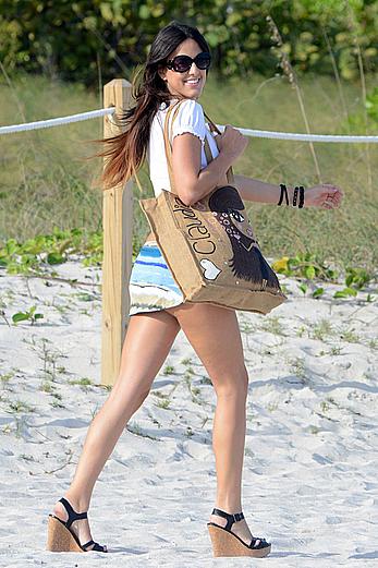 Claudia Romani on the beach in white bikini and jeans skirt