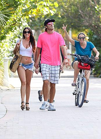 Claudia Romani on the beach in white bikini and jeans skirt