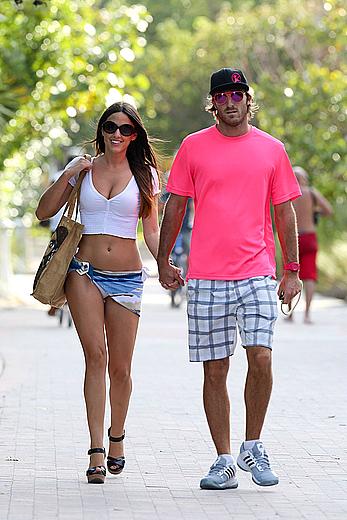 Claudia Romani on the beach in white bikini and jeans skirt