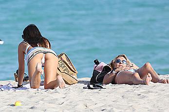 Claudia Romani on the beach in white bikini and jeans skirt