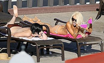 Busty Courtney Stodden getting close with a girlfriend whilst laying poolside