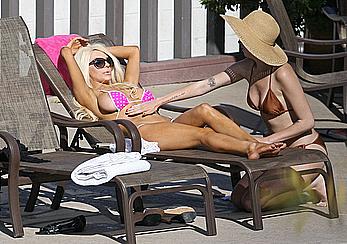 Busty Courtney Stodden getting close with a girlfriend whilst laying poolside