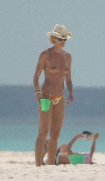 Elle Macpherson topless on a beach