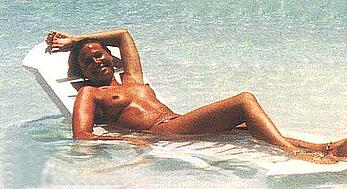 Italian television host and radio personality Federica Panicucci sunbathing topless on a beach