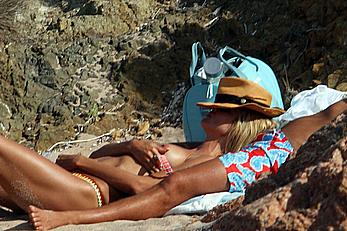 Supermodel Heidi Klum sunbathing topless at a beach in Italy