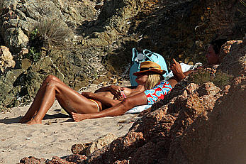 Supermodel Heidi Klum sunbathing topless at a beach in Italy