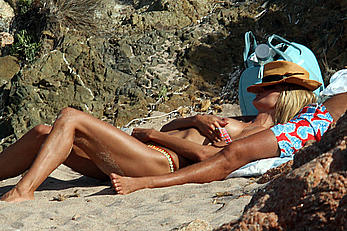 Supermodel Heidi Klum sunbathing topless at a beach in Italy