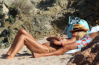 Supermodel Heidi Klum sunbathing topless at a beach in Italy