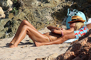 Supermodel Heidi Klum sunbathing topless at a beach in Italy