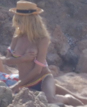 Supermodel Heidi Klum sunbathing topless at a beach in Italy