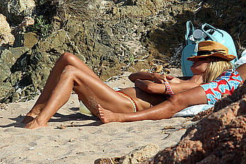 Supermodel Heidi Klum sunbathing topless at a beach in Italy