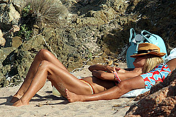 Supermodel Heidi Klum sunbathing topless at a beach in Italy