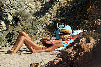 Supermodel Heidi Klum sunbathing topless at a beach in Italy