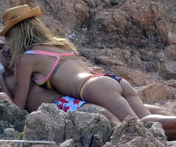 Supermodel Heidi Klum sunbathing topless at a beach in Italy